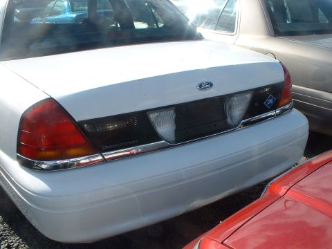 2000 Ford Crown Victoria - The rear of a white Ford Crown Victoria, a 'CNG' sticker and parked next to other vehicles.