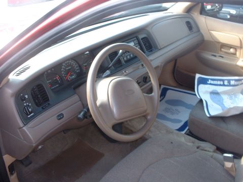 2000 Ford Crown Victoria - The interior of a 2000 Ford Crown Victoria, its dashboard, steering wheel, and a document from James G. Murphy auction preview.