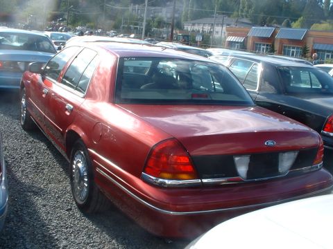 2000 Ford Crown Victoria - Rear view of a red 2000 Ford Crown Victoria parked in a lot with other vehicles.