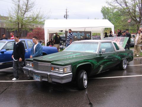 1998 GMC Sierra 1500 - A customized Cadillac coupe with distinctive green pinstripe graphics is displayed outdoors.