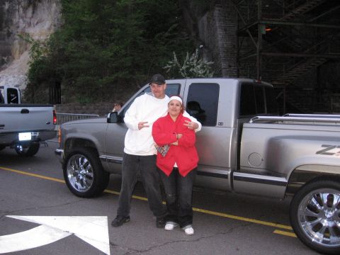 1998 GMC Sierra 1500 - A couple stands by a silver GMC Sierra 1500 pickup truck, which appears to be a 1998 model.