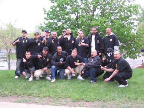 1998 GMC Sierra 1500 - A group of men, some wearing black jackets with patches, pose for a photo outdoors on a grassy area.