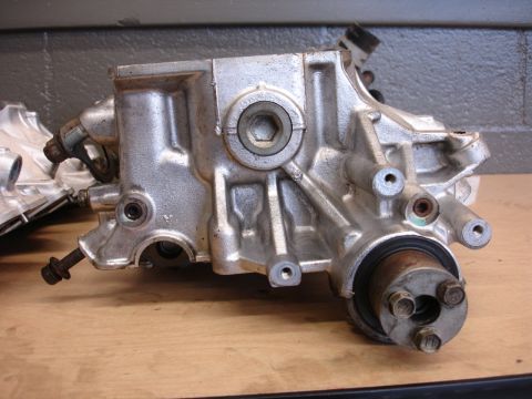 1993 Ford Taurus - A silver metal automotive part, possibly from a transmission, sits on a wooden surface.