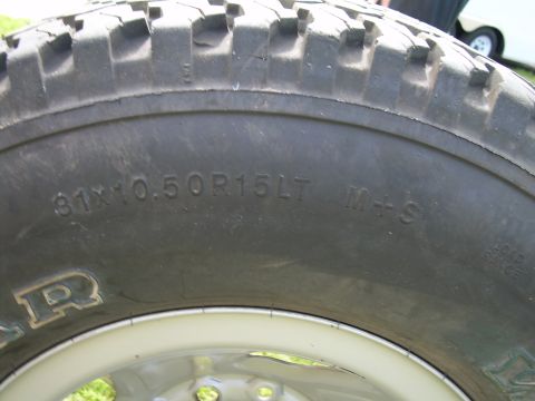 1986 Ford Bronco - Close-up of a tire showing its size and M+S designation, with a portion of the brand name visible.