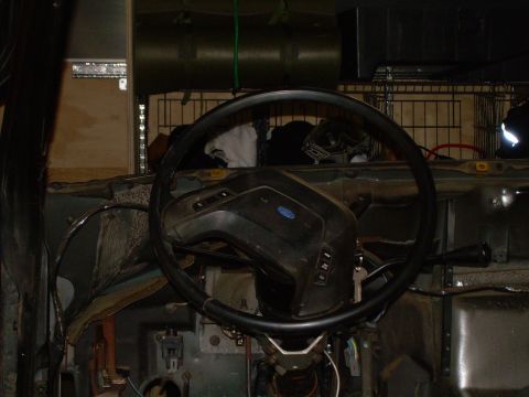 1986 Ford Bronco - Interior view of a vehicle's dashboard, a steering wheel with a Ford emblem and a key in the ignition.