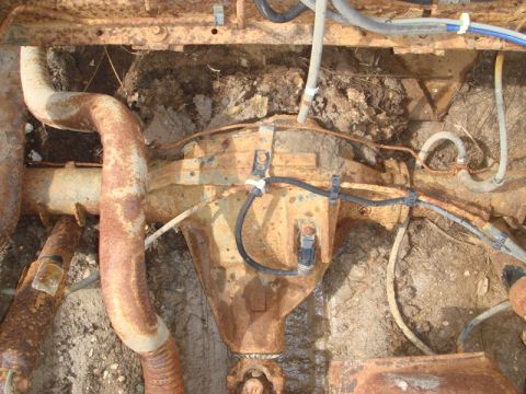 1996 Ford Bronco - Close-up view of a heavily rusted vehicle rear axle and exhaust system components.