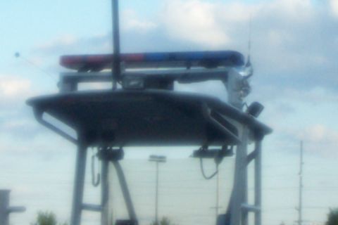 1998 Ford Crown Victoria - A vehicle equipped with emergency lights and communication equipment is viewed from a distance under a cloudy sky.