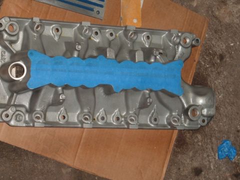 1990 Ford Ranger - An engine intake manifold is prepared for work with blue masking tape covering its mating surface.