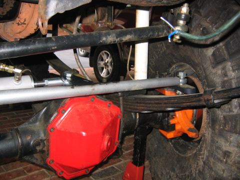 1979 Ford Bronco - Close-up view of a vehicle's suspension and differential, with another car in the background.