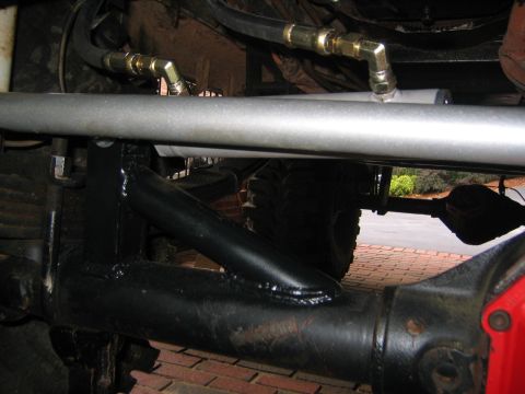 1979 Ford Bronco - Underside view of vehicle suspension and hydraulic lines, possibly during a repair.