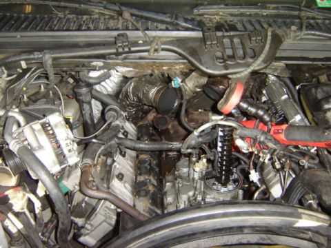 1992 Ford Bronco - Close-up view of a complex engine bay with various mechanical components and wiring harnesses.