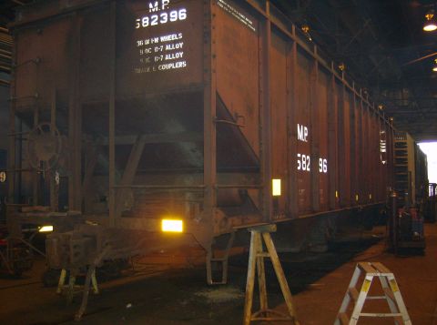 1996 Ford Probe - A large, weathered railroad freight car is shown indoors, resting on support stands.