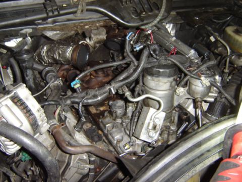 1992 Ford Bronco - Close-up view of a vehicle's engine compartment, showing various mechanical parts and wiring.