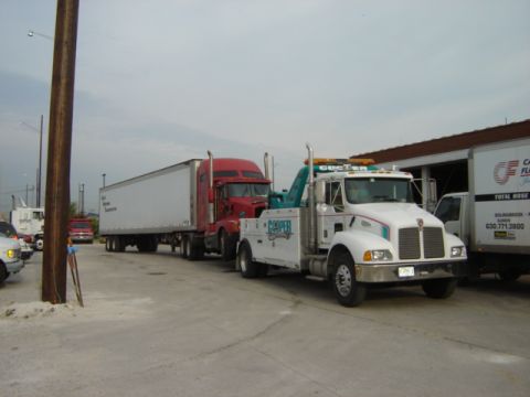 1992 Ford Bronco - A tow truck is shown towing a semi-trailer truck.