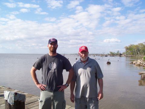 1992 Ford Bronco - Two men pose for a photo on a wooden pier with a wide expanse of water and a distant tree line.