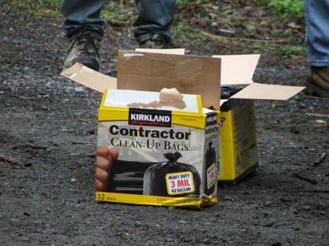 1996 Ford Bronco - Boxes of contractor clean-up bags are placed on the ground, with people's legs visible in the background.