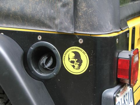 1996 Ford Bronco - A yellow Jeep Wrangler's rear section is visible, showing a skull sticker and a taillight.
