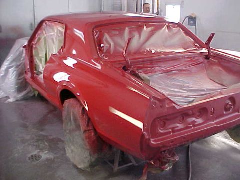 1967 Mercury Cougar - Car body in red primer, doors and trunk open, inside a paint booth.