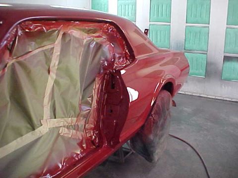 1967 Mercury Cougar - The interior of a red 1967 Mercury Cougar is taped off and covered with plastic sheeting, likely in preparation for painting.