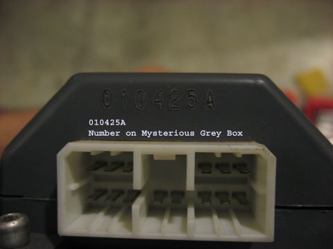 2001 Ford Crown Victoria - Close-up of a grey electronic box with a part number and its electrical connector.