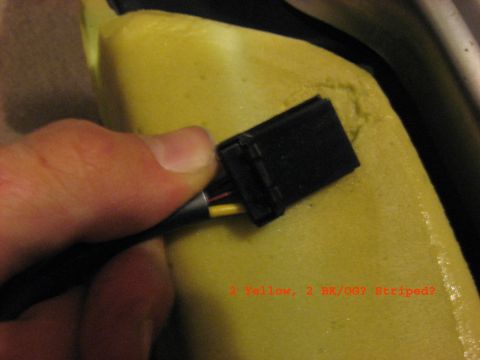 2001 Ford Crown Victoria - A hand connects a wiring harness to a seat cushion, with text noting wire colors.