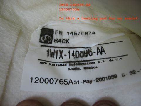 2001 Ford Crown Victoria - Close-up of a label on a car seat heating element, showing part number and manufacturing date.