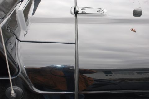 1996 Ford Bronco - The reflection on the glossy black paint shows a landscape with water and buildings.