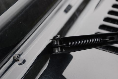 1996 Ford Bronco - A detailed view of a car's windshield wiper assembly, focusing on the mechanical components.