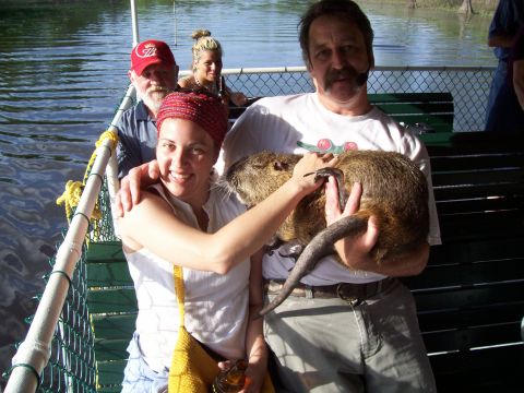 1992 Ford Bronco - A group of people on a boat are posing for a photo while holding a large rodent.