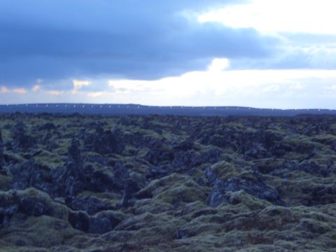 1974 Ford Bronco - A vast, landscape of dark volcanic rock covered in green moss.