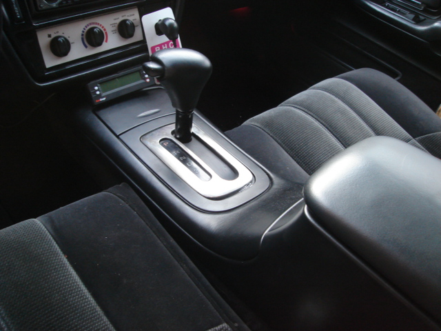Car center console with automatic shifter, climate controls and small display screen