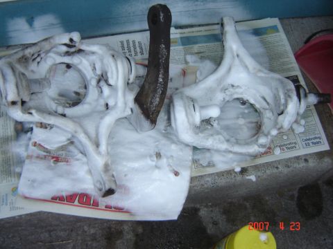 1993 Ford Bronco - Foamy suspension parts sit on newspapers, possibly being cleaned.