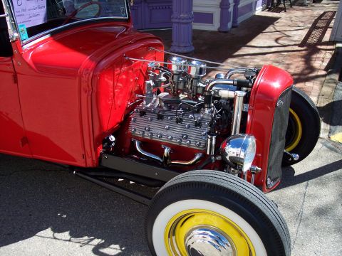 1972 Ford Ranchero - A red hot rod with a V8 engine and chrome accents is parked on a brick walkway.