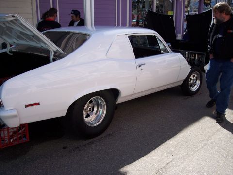 1972 Ford Ranchero - A white coupe with a distinctive body style is parked outdoors, with another vehicle's hood open nearby.