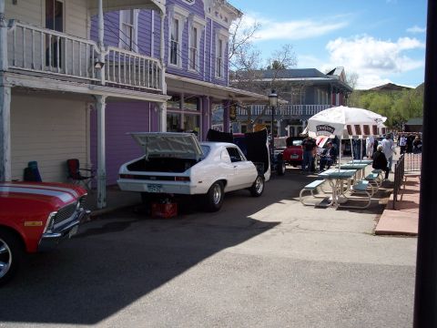 1972 Ford Ranchero - A white coupe with its trunk and hood open is parked on a street, with a red car to its left.