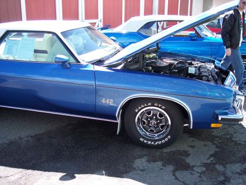1972 Ford Ranchero - A blue coupe with a white top and "442" badging is shown with its hood open, revealing the engine bay.