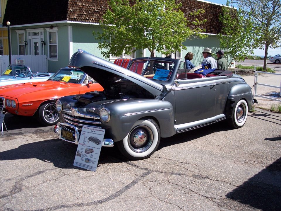 Gray 1946 Ford convertible with hood open, parked next to an orange car