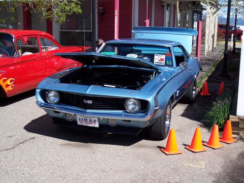 1972 Ford Ranchero - A light blue 1969 Chevrolet Camaro SS is displayed with its hood open, parked alongside a red vintage car.