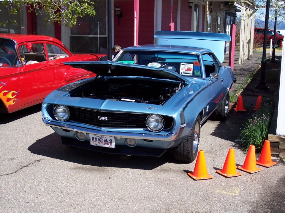 Blue 1969 Chevrolet Camaro SS with hood open, parked next to a red car