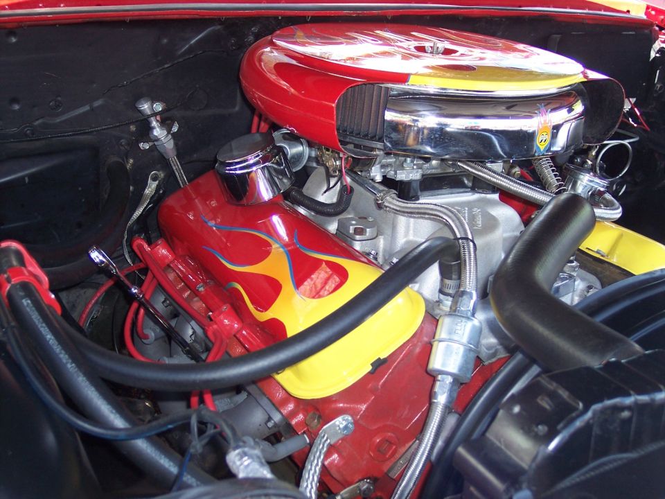 Engine bay with red and yellow flame decals on valve covers and air cleaner