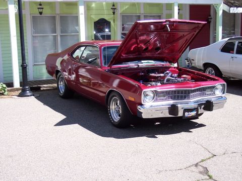 1972 Ford Ranchero - A maroon 1973 Dodge Dart coupe is parked with its hood open, revealing the engine bay.