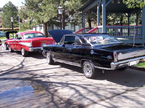 1972 Ford Ranchero - Two classic American cars, a black 1966 Nova and a red 1957 Bel Air, are parked outdoors.