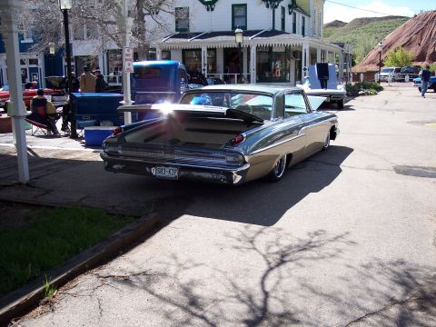 1972 Ford Ranchero - Rear view of a 1959 Mercury Montclair parked on a street with buildings and hills in the background.