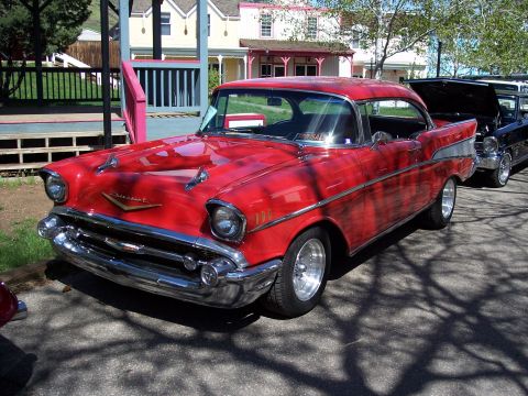 1972 Ford Ranchero - A classic red Chevrolet is parked on a street with houses in the background.