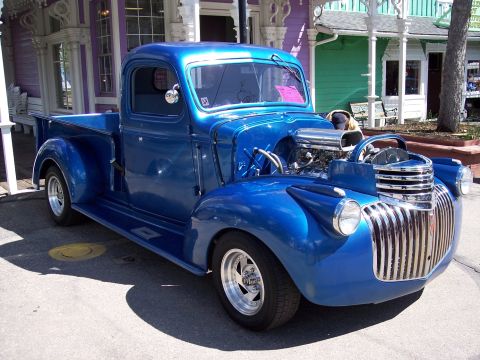 1972 Ford Ranchero - This custom blue pickup truck features a prominent exposed engine and a classic grille design.