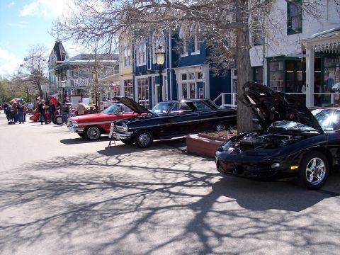 1972 Ford Ranchero - A row of classic cars are displayed on a street in front of buildings.