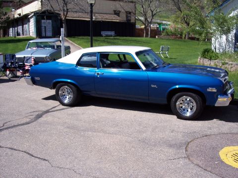 1972 Ford Ranchero - A blue and white coupe, identified as a Nova with a 350 badge, is parked on a street. Another vehicle is visible in the background.