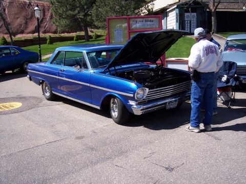 1972 Ford Ranchero - A blue 1966 Chevrolet Nova coupe is parked with its hood open, with people standing nearby.