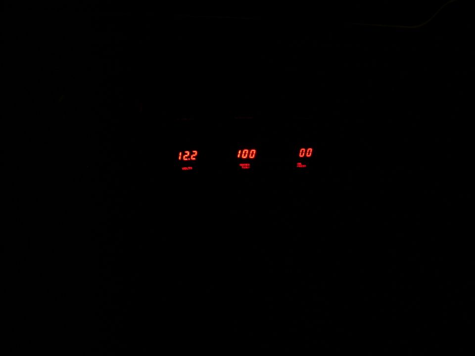 Three red digital gauges showing 12.2, 100, and 00