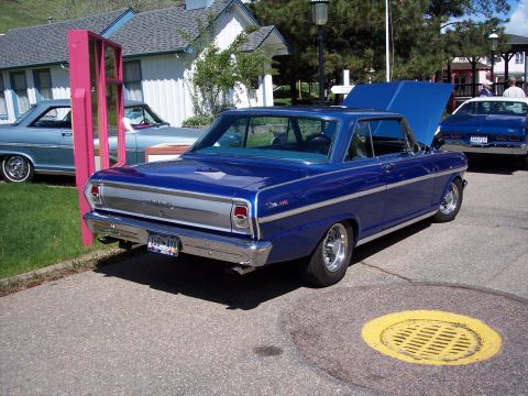 1972 Ford Ranchero - A bright blue 1966 Chevrolet Nova coupe is parked with its hood open, alongside other vehicles.